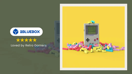 Retro Game Boy-style handheld standing on a pile of colourful blocks with 2Bluebox
