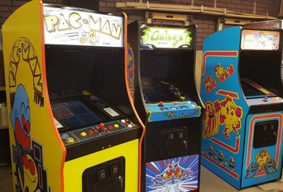 Classic 80s arcade games Galaga and Pac-Man running on a modern living room 4K TV with wireless controllers