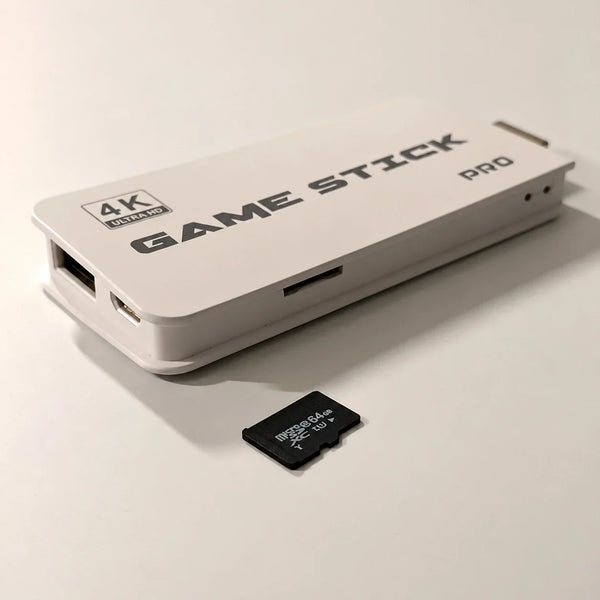White 4K Ultra HD Game Stick Pro HDMI console showing its side TF card slot next to a 64GB microSDXC memory card