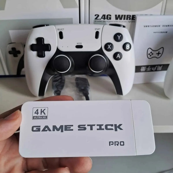 Holding the white 4K Game Stick Pro HDMI dongle and white-and-black PS5-style 2.4GHz wireless controller
