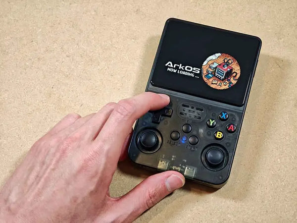 Bench-verified 2BlueBox R36S handheld console booting ArkOS 2.0 on its 3.5-inch IPS screen