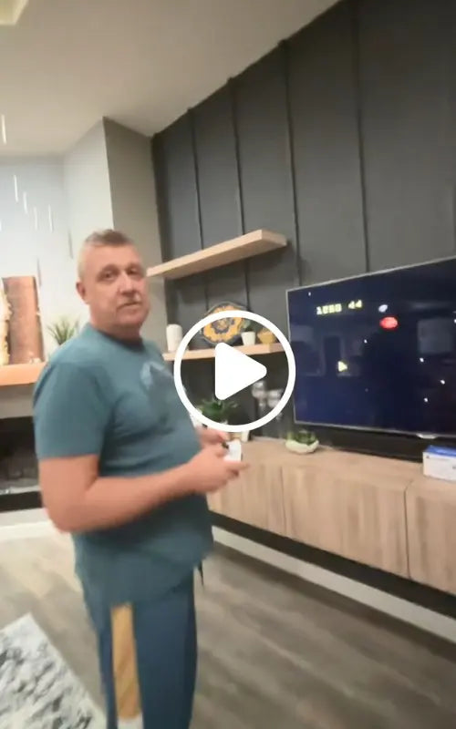 Man is playing 2Bluebox Game Console in a modern living room with a TV