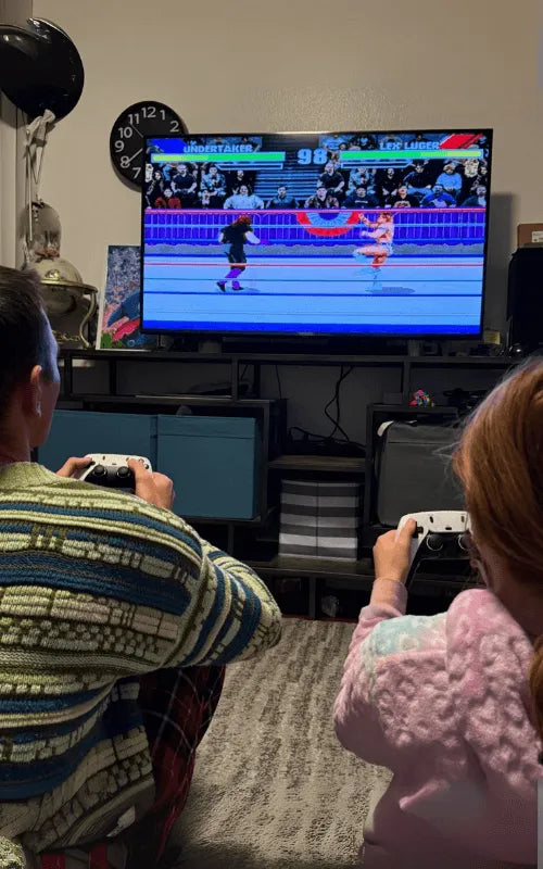 Ryan Gallagher and his daughter are playing a retro video game on a television in a living room.
