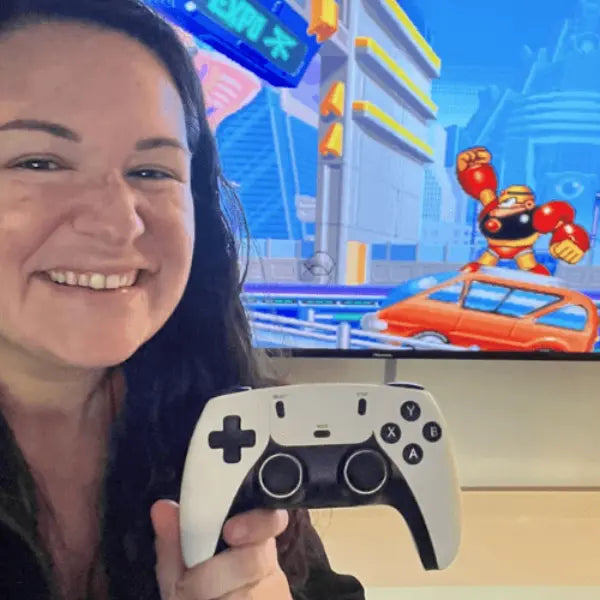 Woman holding 2Bluebox Retro Game Console  in front of a screen displaying a video game.